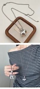 Detail of silver pony pendant necklace featuring a bead chain and stylish design