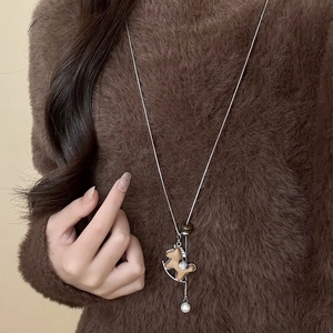Elegante collana maglione con cavallo a dondolo in legno, strass lucidi e perla bianca