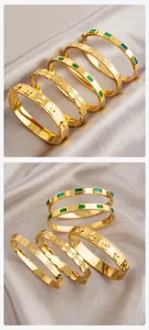 Détail de bracelets en acier titane doré avec zircon taille émeraude et gravures