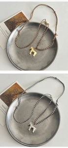 Detail of metallic horse and flower pendant necklaces with braided adjustable cords