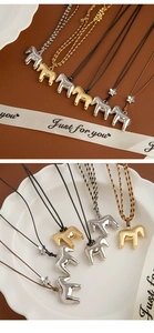 Detailed close-up of metallic horse pendants with floral accents on braided cords