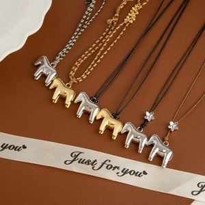 Metallic pony flower pendant necklaces in gold and silver finish on leather surface