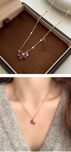 Close-up of golden necklace featuring a red enamel horse pendant with Fu character detail
