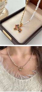 Macro detail of rocking horse pendant necklaces with colorful zircons and pearl chains