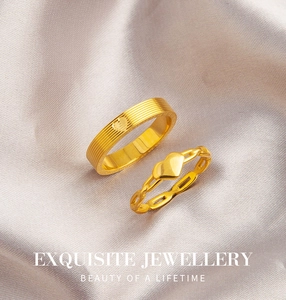 Exquisite gold heart ring set with textured wide band and delicate chain ring on satin fabric