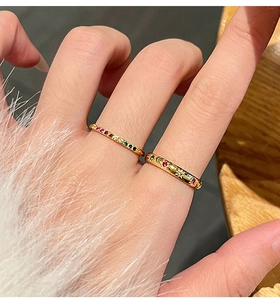 Detailopname van gouden ringen met gekleurde zirkoon en ster- en maanpatronen aan de hand
