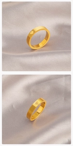 Detail of gold titanium ring with heart engraving, brushed texture and size scale
