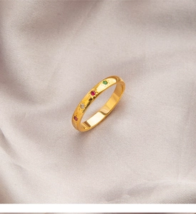 Detail van een gouden sterrenring met kleurrijke zirkoonstenen en gegraveerde patronen