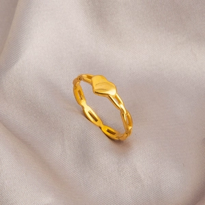 Golden heart ring with hollow geometric chain band on grey satin background