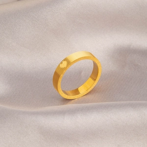 Golden titanium steel heart ring with textured finish and engraved numbers on silk background
