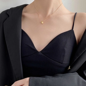 Minimalist matte gold ball gourd pendant necklace for women worn by a model