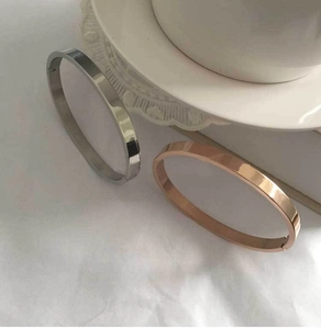 Polished silver and rose gold stainless steel bangle bracelets with hinge clasp detail