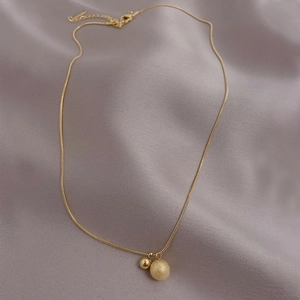 Titanium steel necklace with gold spheres in polished and frosted finish on silk