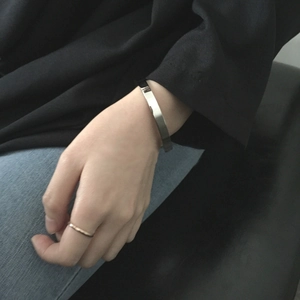 Minimalist silver-tone titanium steel cuff bracelet with rose gold ring worn by model