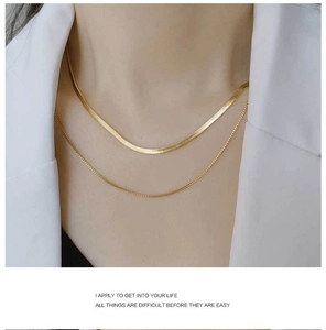 Gros plan d'un collier double rang en or 18 carats avec chaîne serpent et perles