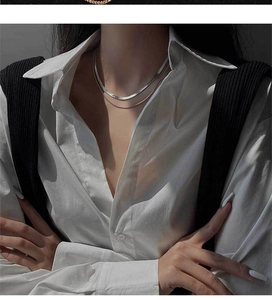 Détail d'un collier double épaisseur en maille serpent argentée porté par un mannequin