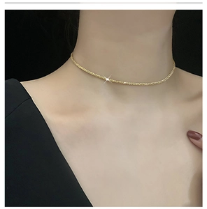 Detailed view of a sparkling gold titanium steel necklace on model showing fine texture