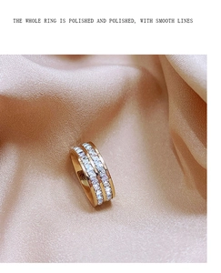 Detail van gepolijste gouden ring met dubbele rij zirkonia op zijden achtergrond