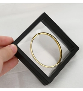 Detalle de caja de exhibición para joyas con película PE negra y anillo de oro flotante