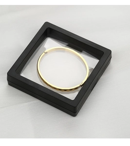 Detalle de una pulsera dorada en una caja de exhibición de película de PE negra