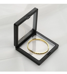 Detalle de un brazalete dorado con rombos en una caja expositora flotante de PE