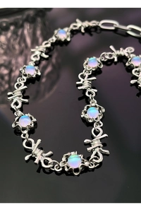 Dettaglio macro della collana a catena a spine con gemme tonde stile pietra di luna