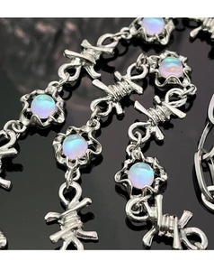 Dettaglio macro della collana a catena a filo spinato argento con ciondolo opale