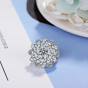 Sparkling flower brooch with zircon stones in silver metal on an elegant white background