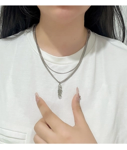 Close-up of double layer titanium steel necklace with feather pendant and mixed chain styles