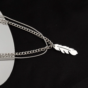 Double-layer titanium steel necklace with a detailed feather pendant and chunky Cuban chain