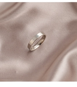 Polierter silberner Edelstahl-Ring im minimalistischen Design auf edler Champagner-Seide