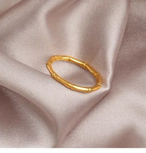 Macro detail of golden bamboo knot texture on a minimalist titanium steel ring