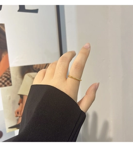 Detail view of a bamboo-joint style gold titanium steel ring on a model index finger
