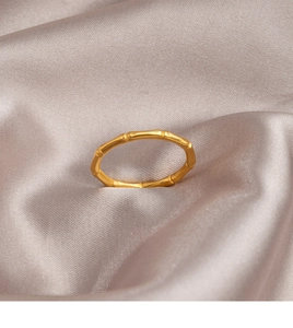 Detailed close-up of a gold bamboo-shaped titanium steel ring on silk background