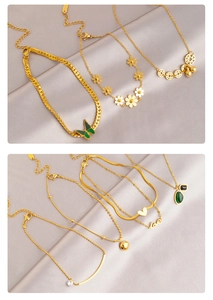 Nahaufnahme von 18K Gold Titan Fußkettchen mit grünem Schmetterling und Gänseblümchen auf Seide
