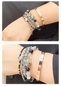 Details van hartvormige kralen en roségouden schroefarmband op een zwart pak manchet