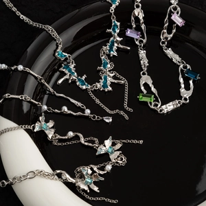 Titanium butterfly pearl necklace set with blue and green gemstones on black tray