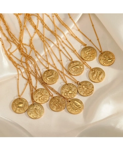 Collection détaillée de pendentifs zodiaque dorés en relief sur fond de soie