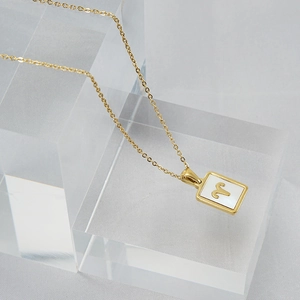 Detail der goldenen Widder Sternzeichen Kette mit weißem Perlmutt Inlay auf Blöcken