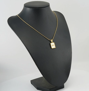 Detail of 18K gold Pisces necklace with mother-of-pearl inlay on snake chain