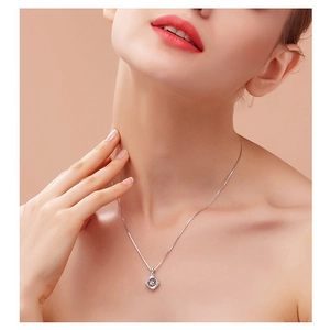 Collier trèfle à quatre feuilles en argent avec pierre ronde porté par une femme