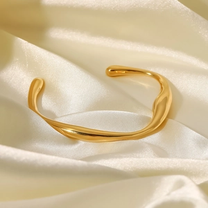 Poliertes, 18K vergoldetes Edelstahl-Armband in unregelmäßiger Form auf Seide