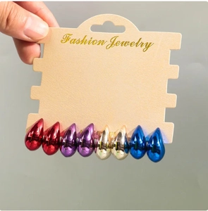 Set of four glossy metallic teardrop earrings in red, purple, gold and blue on a display card