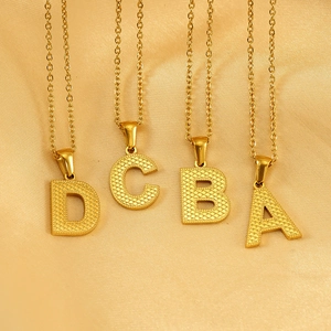 Golden letter pendant necklaces A-B-C-D with honeycomb texture on silk background