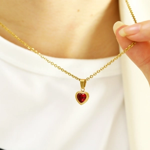 Detail of a vintage heart-shaped red zircon pendant on a gold-plated necklace for women