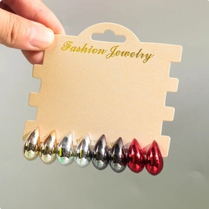 Detailed set of teardrop earrings in gold, silver, black, and red finishes on card