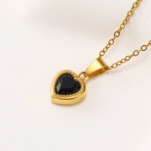 Detailed macro view of heart-shaped black zircon pendant with gold beaded bezel