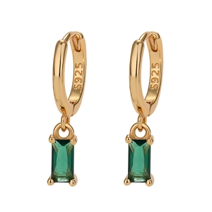 Macro detail of S925 sterling silver stamp on gold hoops with emerald zircon pendants