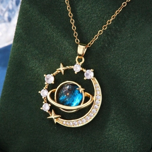 Close-up of golden blue planet necklace with zircons on a green velvet stand