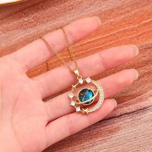 Detailed macro of gold planet necklace with blue nebula orb and starry zircon accents